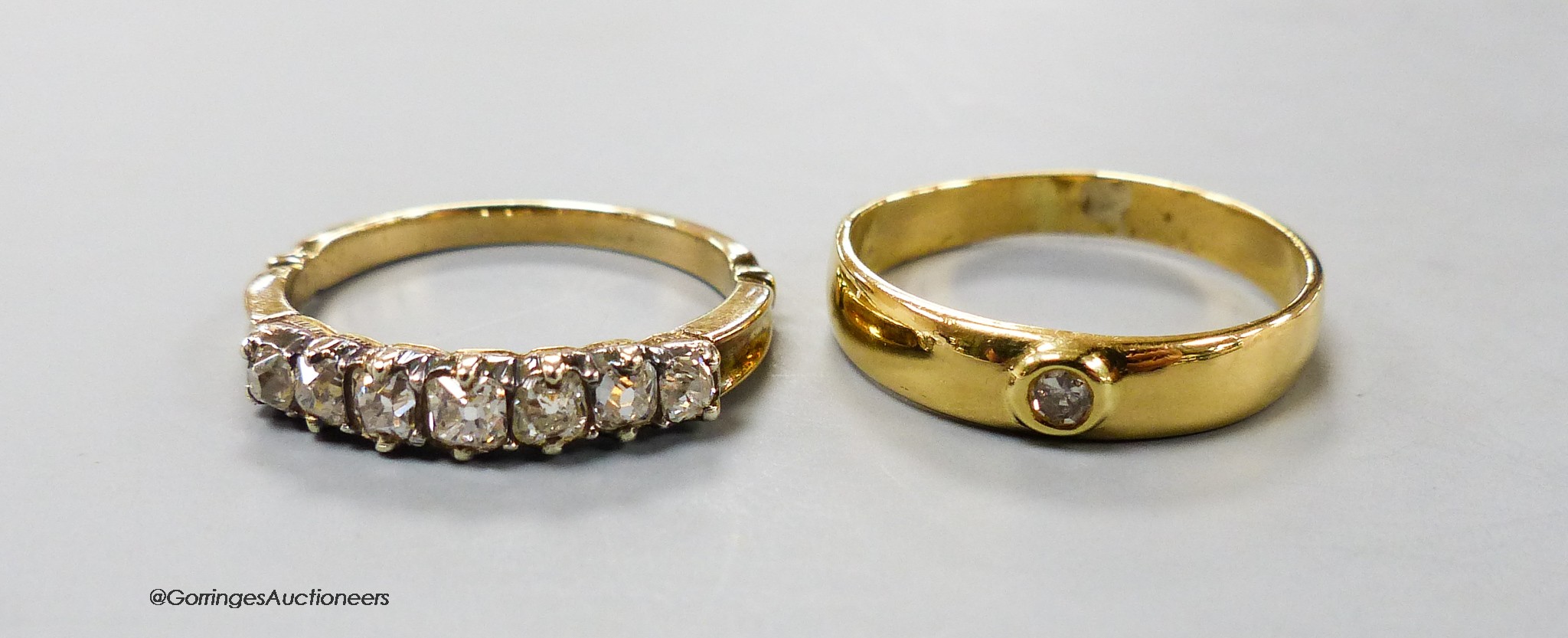 A yellow metal and graduated seven stone diamond set half hoop ring, size O and one other solitaire diamond set ring, gross 6.2 grams.